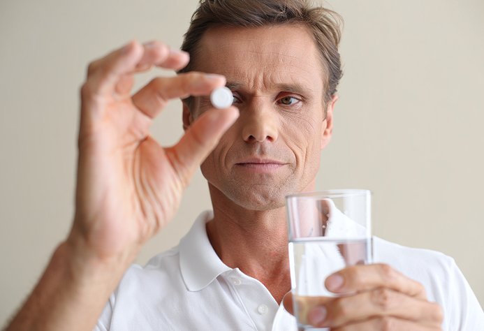 Мужчина собирается принять лекарство